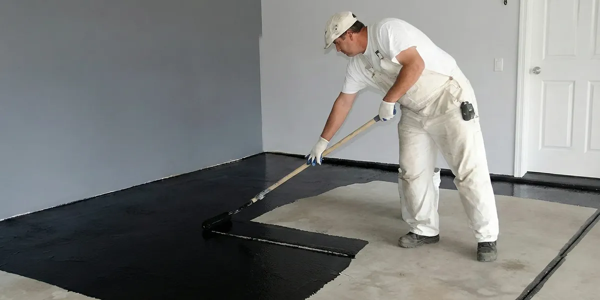 basement waterproofing professional applying waterproof coating to protect a basement floor in Scottsdale, AZ